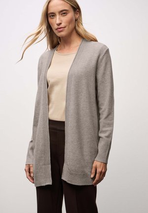 Ljusgrå lång cardigan i mjukt material med ribbad kant utan knäppningar, kombinerad med en beige topp och mörka byxor.