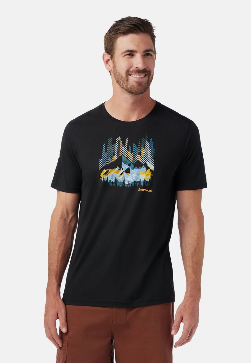 Zwarte t-shirt met korte mouwen, versierd met een kleurrijke bergafbeelding in blauw, geel en groen tinten, gemaakt van zachte stof.