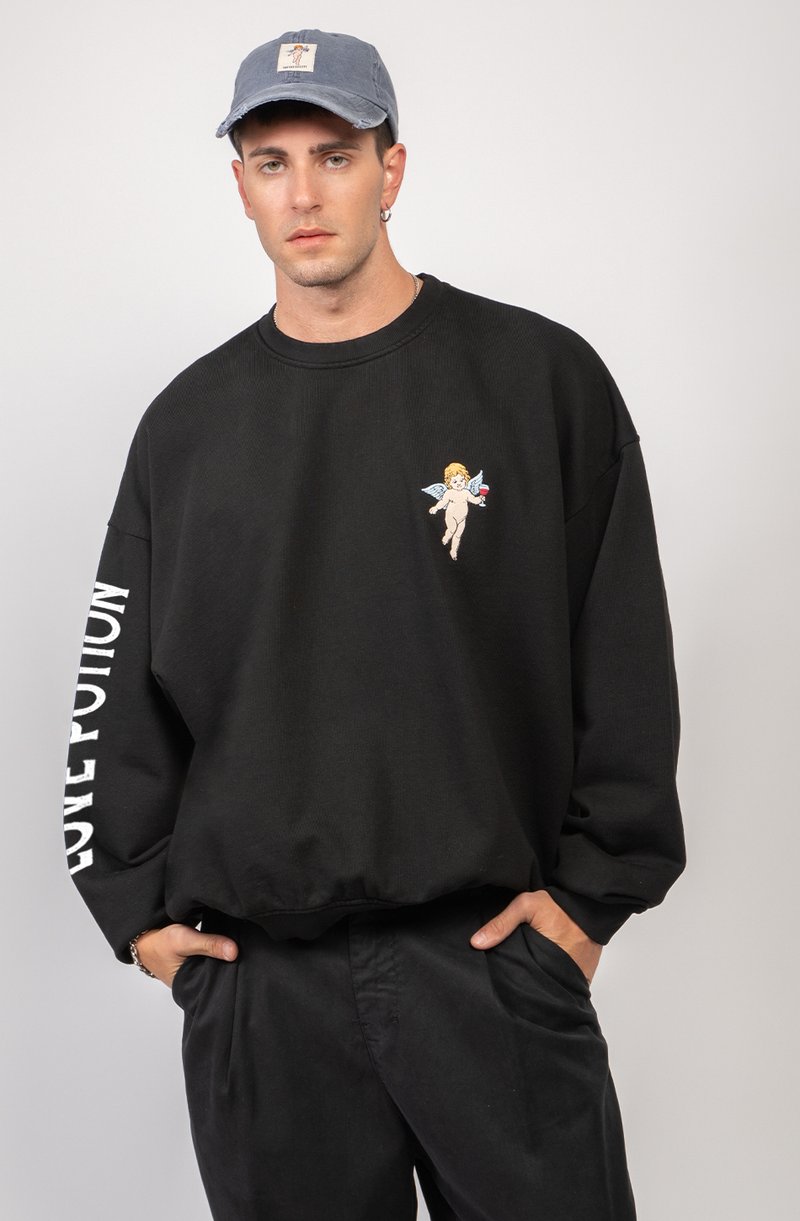 Sudadera negra de gran tamaño con textura acanalada, que presenta un pequeño diseño de un querubín bordado en el pecho y el texto "POTION DE AMOR" en la manga.