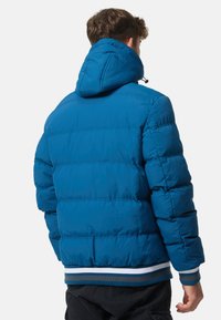 Blue padded jacket featuring a hood, horizontal stitching, and a ribbed hem with blue, white, and brown stripes. Back view displayed.