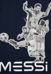 Marineblå t-shirt med et grafisk design af tre fodboldspillere i bevægelse, med navnet "MESSI" trykt i fede hvide bogstaver nederst.