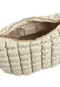 Borsa a mano in pelle crema con texture trapuntata, cerniera dorata e etichetta interna. Presenta sezioni morbide e arrotondate e una fodera liscia.