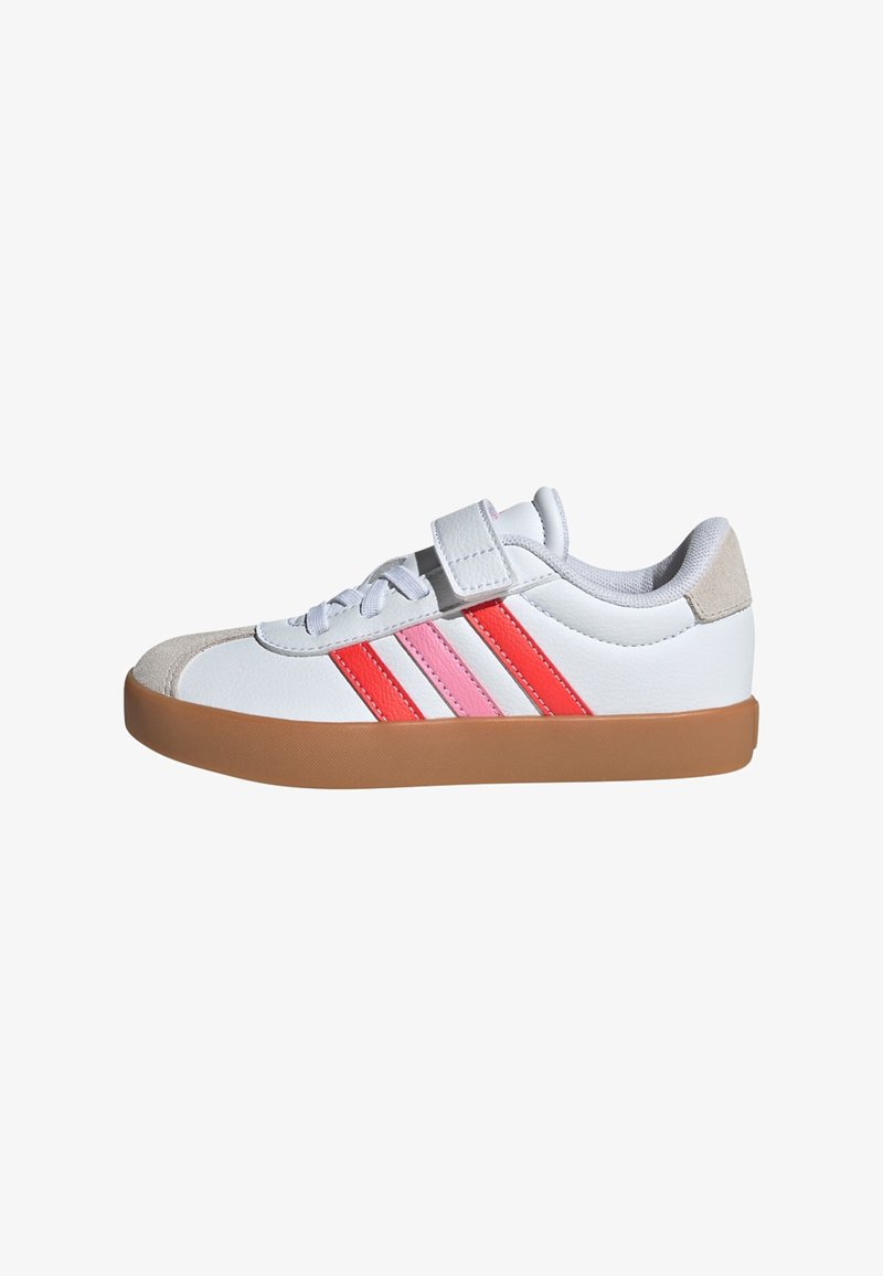 Zapatilla blanca con rayas rosas y rojas, con una puntera de ante y una suela de goma marrón. Presenta cordones y una correa de velcro para el cierre.