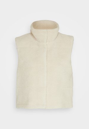 Colete de polar na cor creme com um colarinho alto, apresentando uma superfície texturizada e um design quadrado. Sem mangas ou fechos visíveis.