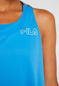 Blå ärmlös sporttopp med en mjuk textur och Fila-logotyp i vitt. Har en kontrasterande mönstrad halslinning.
