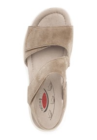 Beige suède sandaal met dubbele verstelbare banden, een gevormde voetbed en een witte rubberen zool, met een gladde textuur en logo detail.