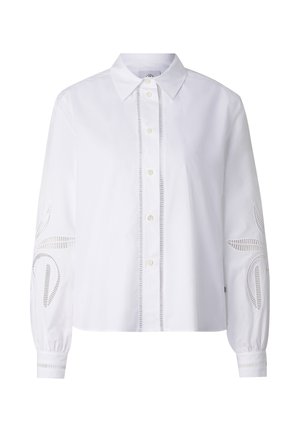 Bílá košile na knoflíky s špičatým límečkem, dlouhými rukávy a dekorativními výřezy na rukávech a přední liště.