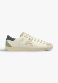 Baskets en cuir blanc avec des accents beige clair, talon en suede vert et marine, semelle en caoutchouc, arborant un logo brodé de tête de mort et os croisés.