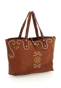 Borsa tote in pelle marrone con motivi floreali e decorativi a volute, arricchita da dettagli metallici e borchie ornamentali, doppio manico e design a apertura superiore.