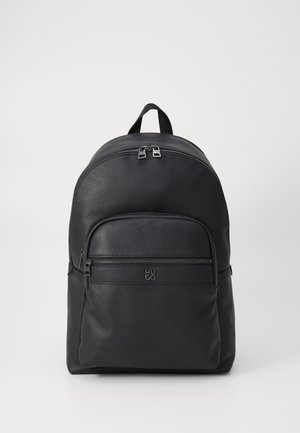 Black leather backpack with a textured finish. Features a front zip pocket, dual top zippers, and a logo on the front. Rounded shape.