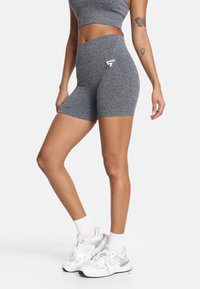 Sivé športové šortky vyrobené z textúrovanej tkaniny, s vysokým pásom a detailom loga. Spárované s bielymi teniskami a ponožkami.