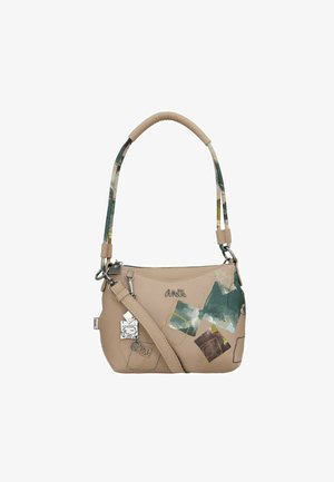 Bolso de mano de cuero beige con forma curva, decorado con gráficos abstractos en verde, azul y marrón. Presenta un llavero decorativo y una correa ajustable.