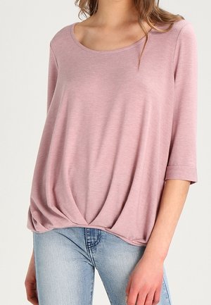 Lichtroze, relaxed fit top met een ronde halslijn en driekwart mouwen. Het materiaal lijkt zacht met een geplooid detail aan de zoom.