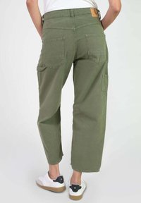 Pantalones cargo de pierna ancha en verde oliva con cintura alta, que cuentan con dos bolsillos traseros y un bolsillo lateral, fabricados en tela de algodón.