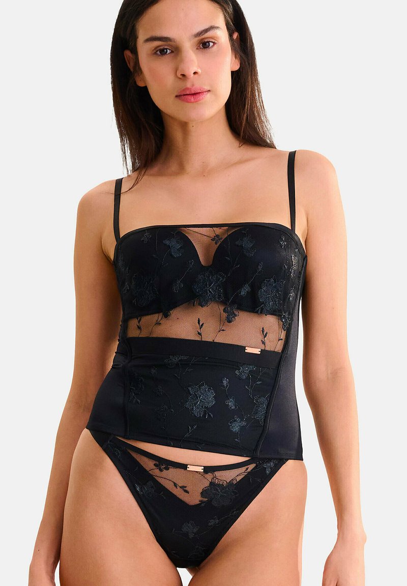 Zwart lingerieset met een doorschijnende mesh top met bloemenborduursel, verstelbare bandjes en een bijpassende low-rise onderkant met decoratieve hardware.