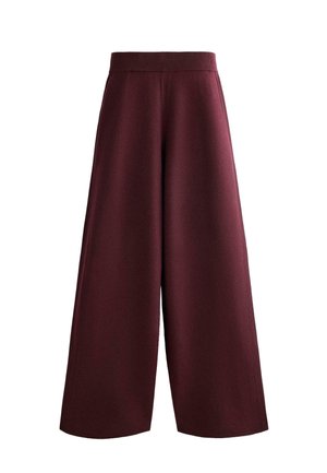 Ženské kalhoty s širokými nohavicemi z texturované bordó látky. Mají vysoký elastický pas a volný, splývavý střih; žádné viditelné kapsy.