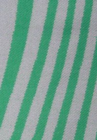 Textil mit abwechselnd grünen und weißen diagonalen Streifen. Der Stoff hat eine strukturierte Oberfläche, die ein gewebtes Muster zeigt.