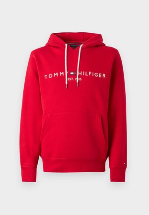 Roter Hoodie aus Baumwollmischung mit einer vorderen Kängurutasche, Kordeln und weißem Logo-Text "TOMMY HILFIGER EST. 1985" auf der Brust.