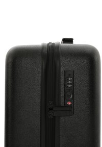 Svart hård skal resväska med en texturerad yta, dubbel dragkedja, kombinationslås och TSA-godkända säkerhetsfunktioner.