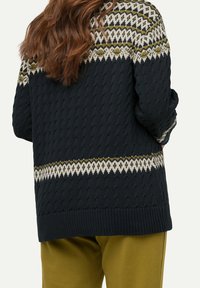Stickad tröja i mörkblått med ett strukturerat mönster, som har en Fair Isle-design i krämfärgad och olivgrön över axlarna.