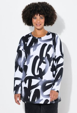T-shirt à manches longues en blanc avec un impression graphique noire audacieuse. Encolure arrondie et coupe décontractée. Texture douce, fabriquée en tissu extensible.