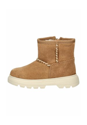 Beżowe zamszowe botki za kostkę z detalami w postaci przeszyć, teksturowanym wnętrzem i białą gumową podeszwą. Posiadają zaokrąglony nosek oraz niski profil.