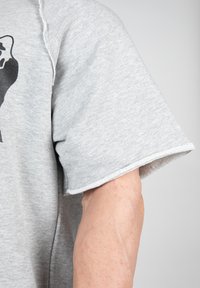 Grijze T-shirt met korte mouwen, voorzien van een rauwe zoom. Zachte, gestructureerde stof met een casual ontwerp. Geen zichtbare patronen of graphics.