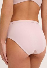 Completo intimo alto rosa chiaro in tessuto morbido, con cintura cucita e dettagli decorativi sul bordo. Presenta una schiena a copertura totale.