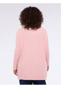 Maglione rosa chiaro oversize con trama a coste sulle maniche, caratterizzato da un orlo arrotondato e un design di lunghezza media.