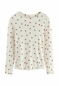 Long-sleeve cream top featuring a ribbed texture and an all-over pattern of small red hearts. Scalloped hem and round neckline.