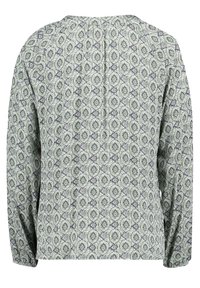 Langärmlige Bluse mit rundem Ausschnitt, die ein kompliziertes Muster in Grün und Marineblau auf einem hellen Hintergrund zeigt.