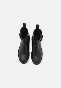 Czarne skórzane botki za kostkę z gładkim wykończeniem, okrągłym czubkiem i złotymi akcentami. Zawierają pull tabsy ułatwiające zakładanie.