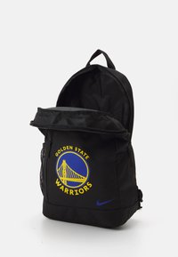 Mochila negra con forma redondeada, que presenta un gran logo de los Golden State Warriors en azul y amarillo. Incluye un bolsillo frontal y un bolsillo lateral de malla.