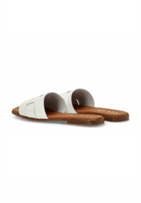 Sandalias de cuero blanco con suela plana marrón. Presentan un diseño de tira trenzada y un lado abierto para facilitar su uso.