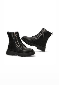 Botines de cuero negro con puntera redonda, cordones en la parte delantera, cremalleras laterales y una suela de goma gruesa. Acentos texturizados en los lados.