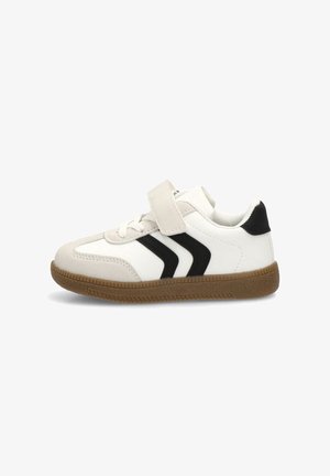 Zapatilla blanca con detalles en negro y tres franjas negras en el lateral. Cuenta con una suela de goma texturizada y una correa de velcro para el cierre.