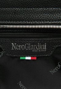 Bolso de cuero negro texturizado con cremallera plateada, que cuenta con un parche con logotipo y un pequeño detalle de la bandera italiana. Forrado con tela negra estampada con la marca.