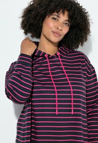 Gestreepte capuchontrui met zwarte en roze horizontale strepen, trekkoordsluiting en een losse pasvorm. Zacht, rekbaar katoenmateriaal.