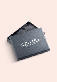 Grå smykkeboks med tekstureret overflade og sort indvendig, med "Sofia Milani JEWELS" i hvid skrift på låget.