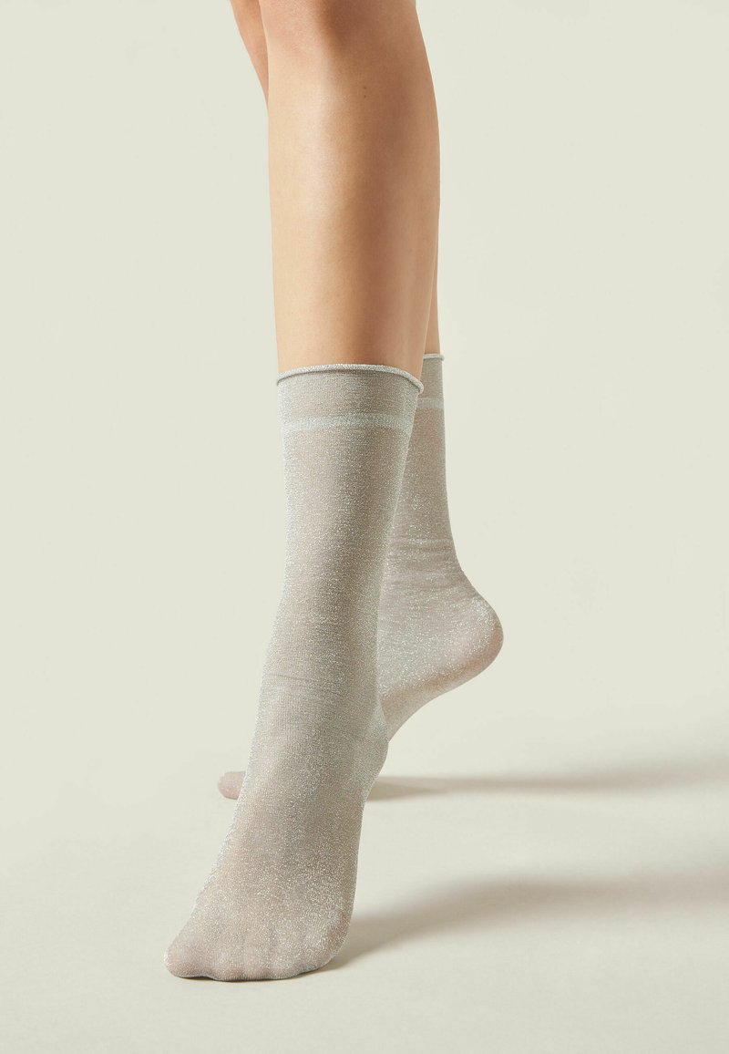 Calcetines tobilleros de color gris claro, hechos de un material transparente y brillante. Presentan un puño acanalado y una textura suave con un leve brillo en toda su superficie.