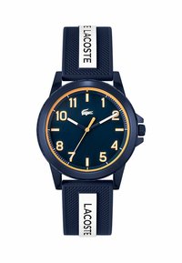 Montre en silicone marine avec un cadran rond, des index dorés et des accents blancs. Elle présente un bracelet texturé avec le nom de la marque clairement affiché.