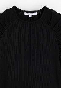 Top negro con textura acanalada y detalles fruncidos en los hombros, escote redondo y etiqueta que dice "SCALPERS", talla pequeña. Textura suave y diseño ajustado.