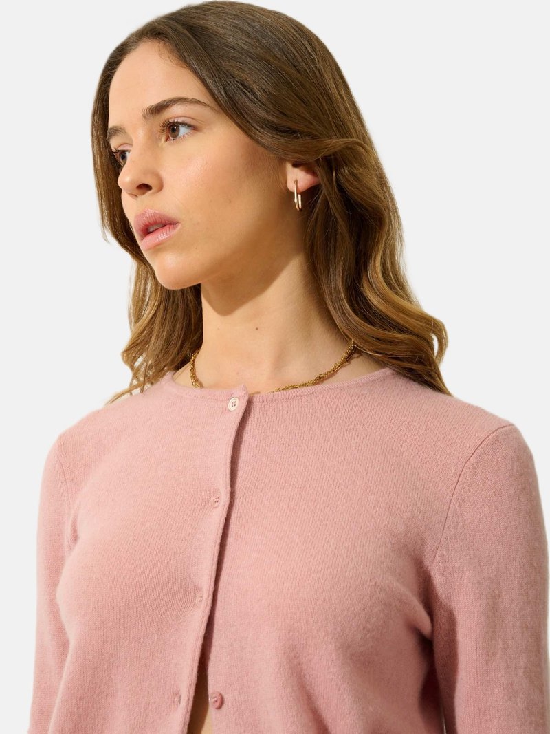 Lichtroze cardigan van zachte stof, met een ronde halslijn, lange mouwen en knoopsluiting. Vlotte textuur met minimale details.