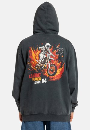 Czarna bluza z kapturem z graficznym nadrukiem motocyklisty na tle ognistej sceny, z tekstem "PRZEWODZENIE W STAWCE OD 94" w wyrazistych kolorach.