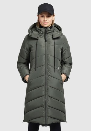 Manteau long rembourré en vert olive avec fermeture éclair à l'avant, capuche amovible, cordon de serrage et quilting en chevrons. Comprend des poches latérales et des poignets élastiques.