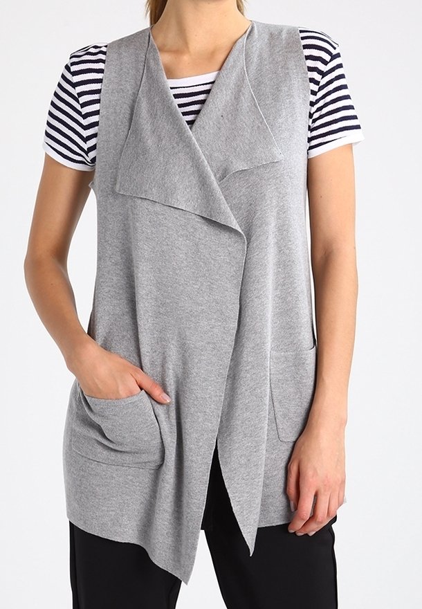 Šedá bezrukávová vesta s volným předním dílem, vyrobená z měkké tkaniny. Obsahuje dvě přední kapsy a vrstvený design přes pruhované tričko.