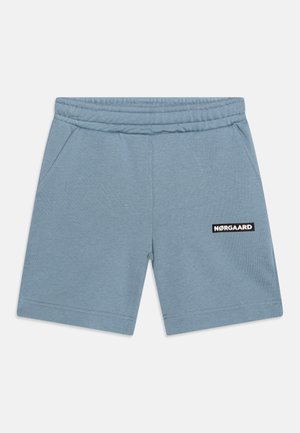 Hellblaue, weiche Baumwollshorts mit elastischem Bund, Seitentaschen und schwarzem Nørgaard-Logo-Patch auf der Vorderseite.