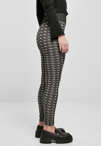 Sorte og grå mønstrede leggings med en tilpasset design, som har en teksturert midjebånd og et gjentakende houndedstooth-mønster.