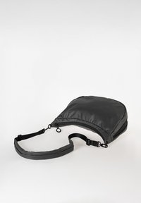 Zaino nero, testurizzato con una finitura liscia, un'unica tracolla regolabile e chiusura con zip. Presenta un design elegante e moderno.
