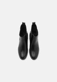 Bottines noires en cuir lisse, dotées de panneaux latéraux élastiques, de languettes de tirage, de bouts arrondis et d'une semelle plate. Taille 37 indiquée à l'intérieur.